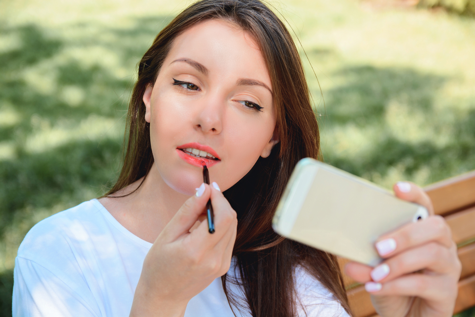 mujer pintando labios smartphone